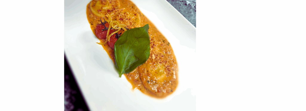 Huisgemaakte ravioli met pesto ricotta, kruidige tomatensaus en geconfijte citroen